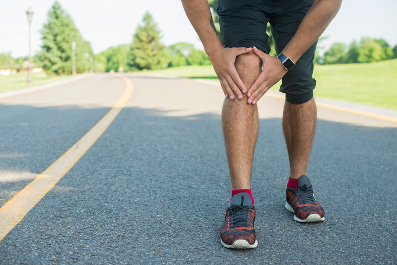Athletic man having knee joint pain